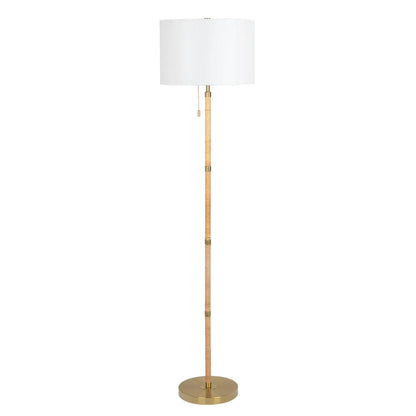 Floor lamp with a white shade and brass base on a white background