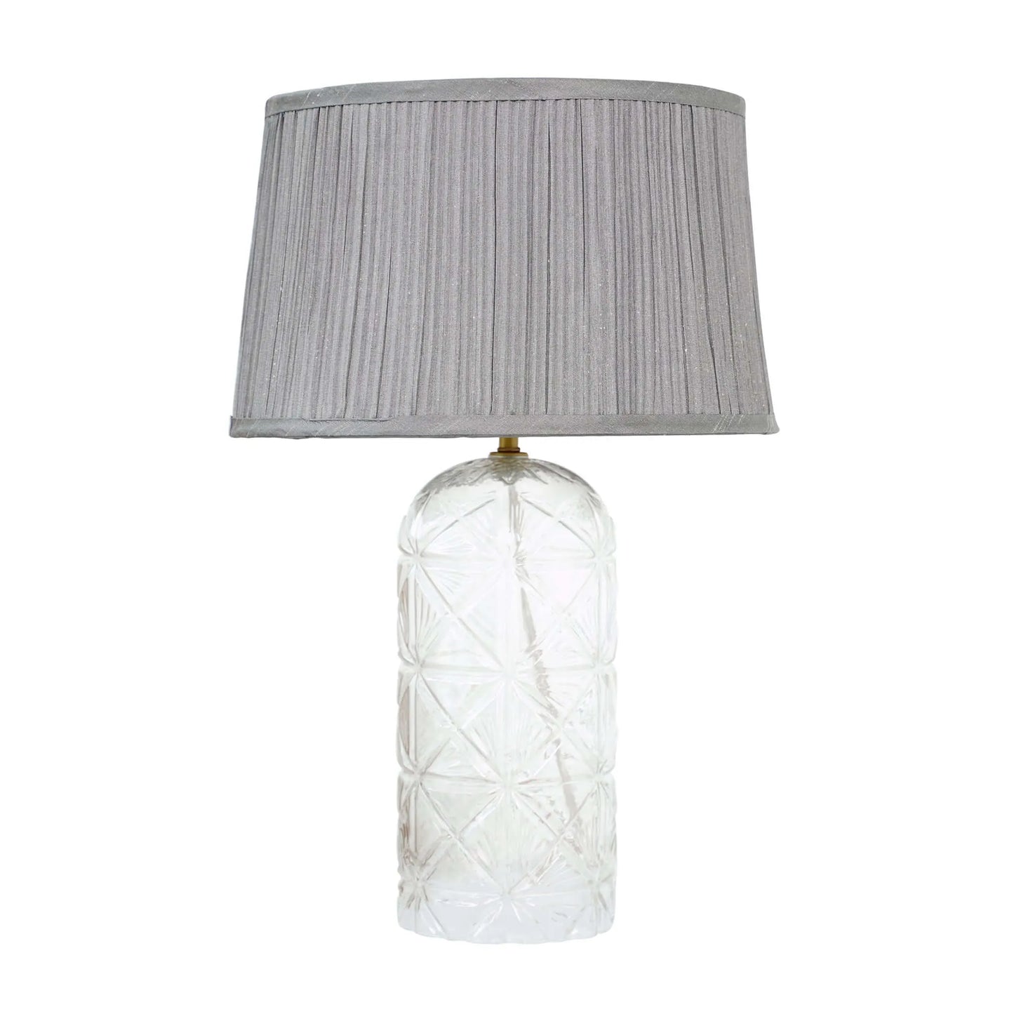 Table lamp with textured glass base and gray pleated shade on a white background