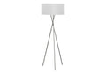 Tripod floor lamp with silver legs and a white shade on a white background