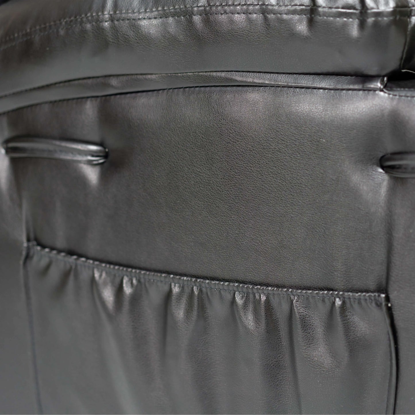 Close-up of a storage pocket with stitching details on a black faux leather power lift recliner chair
