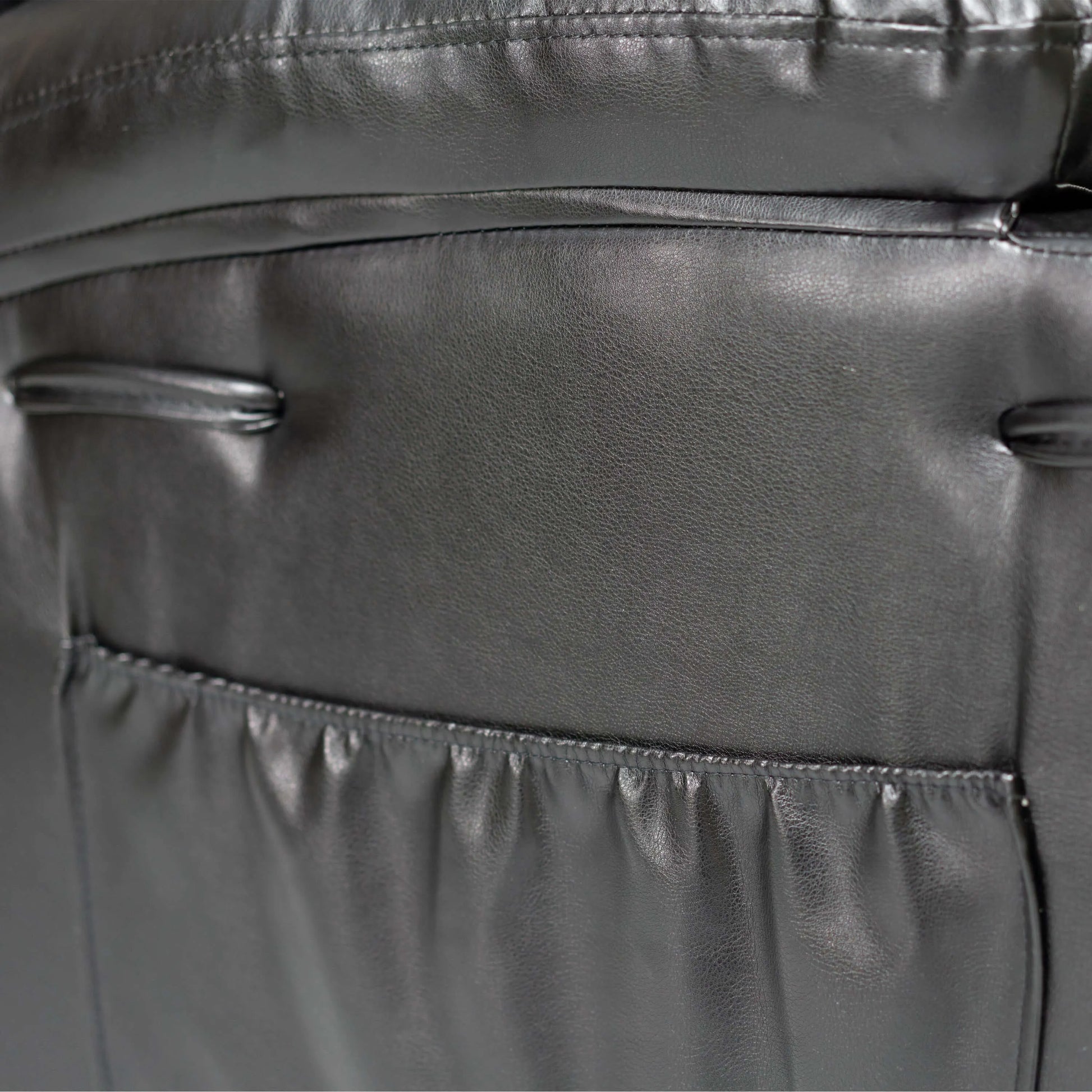 Close-up of a storage pocket with stitching details on a black faux leather power lift recliner chair