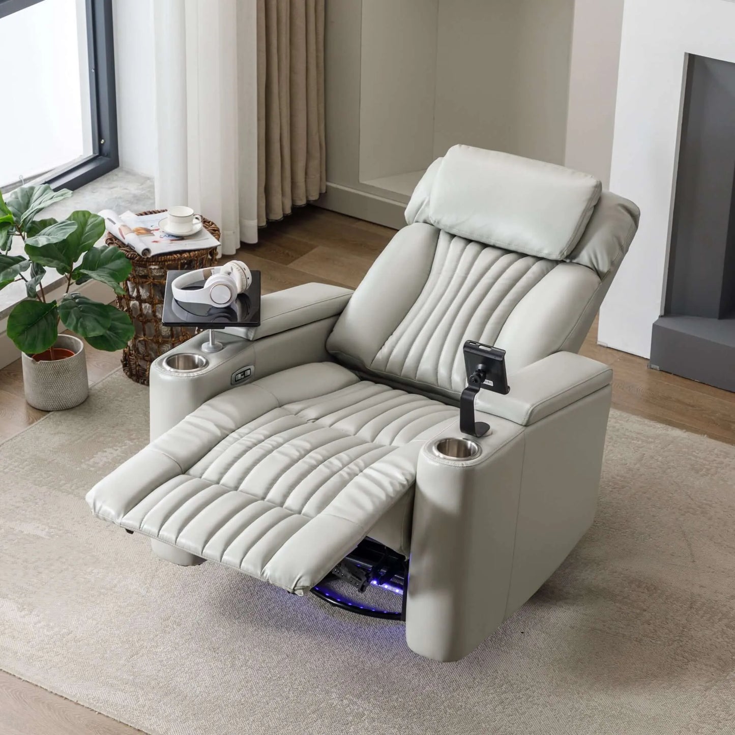 Modern gray leather recliner chair with cup holders and built-in phone holder in a living room setting.