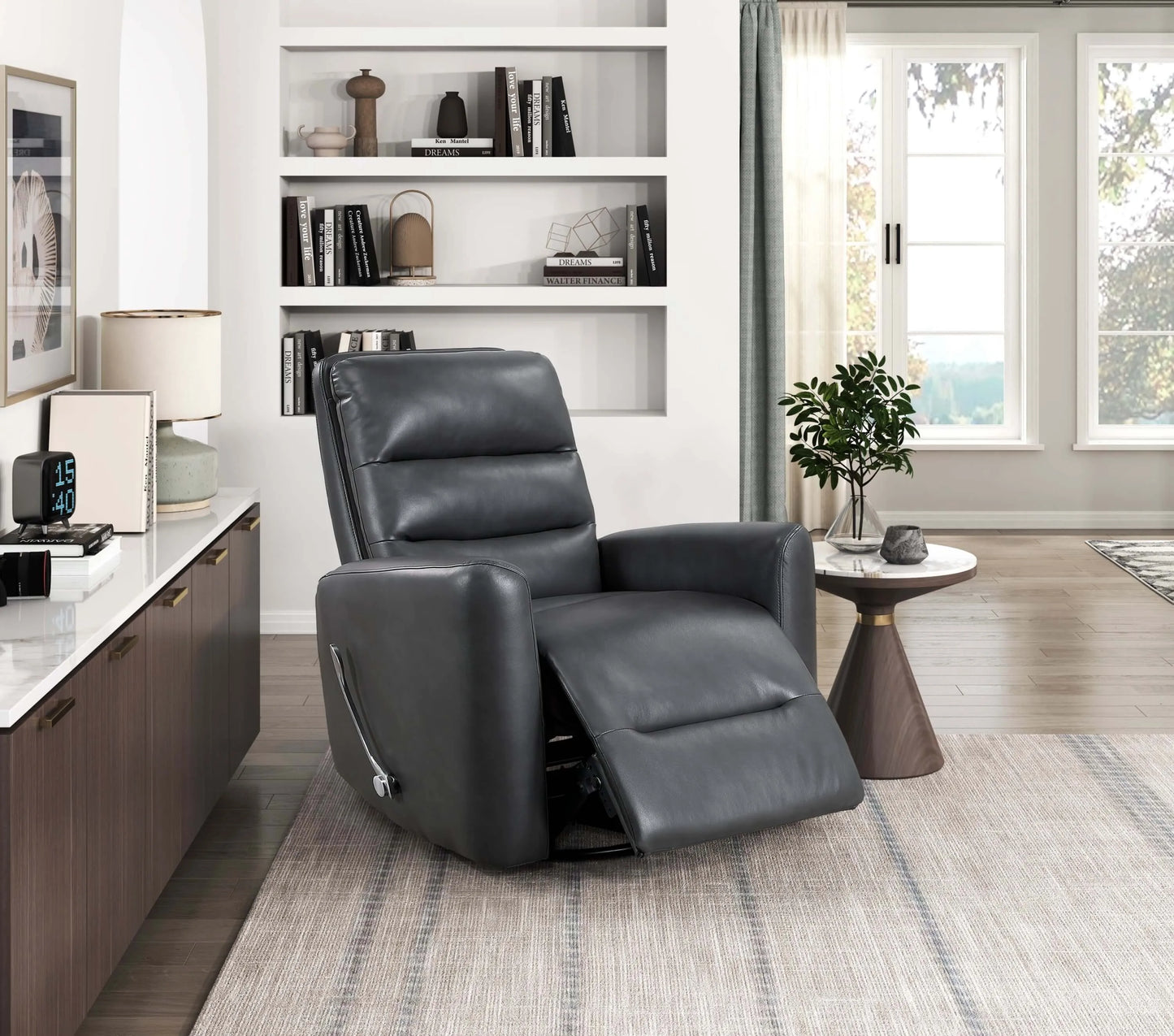 Gray leather recliner chair in a modern living room setting with bookshelves and a window.