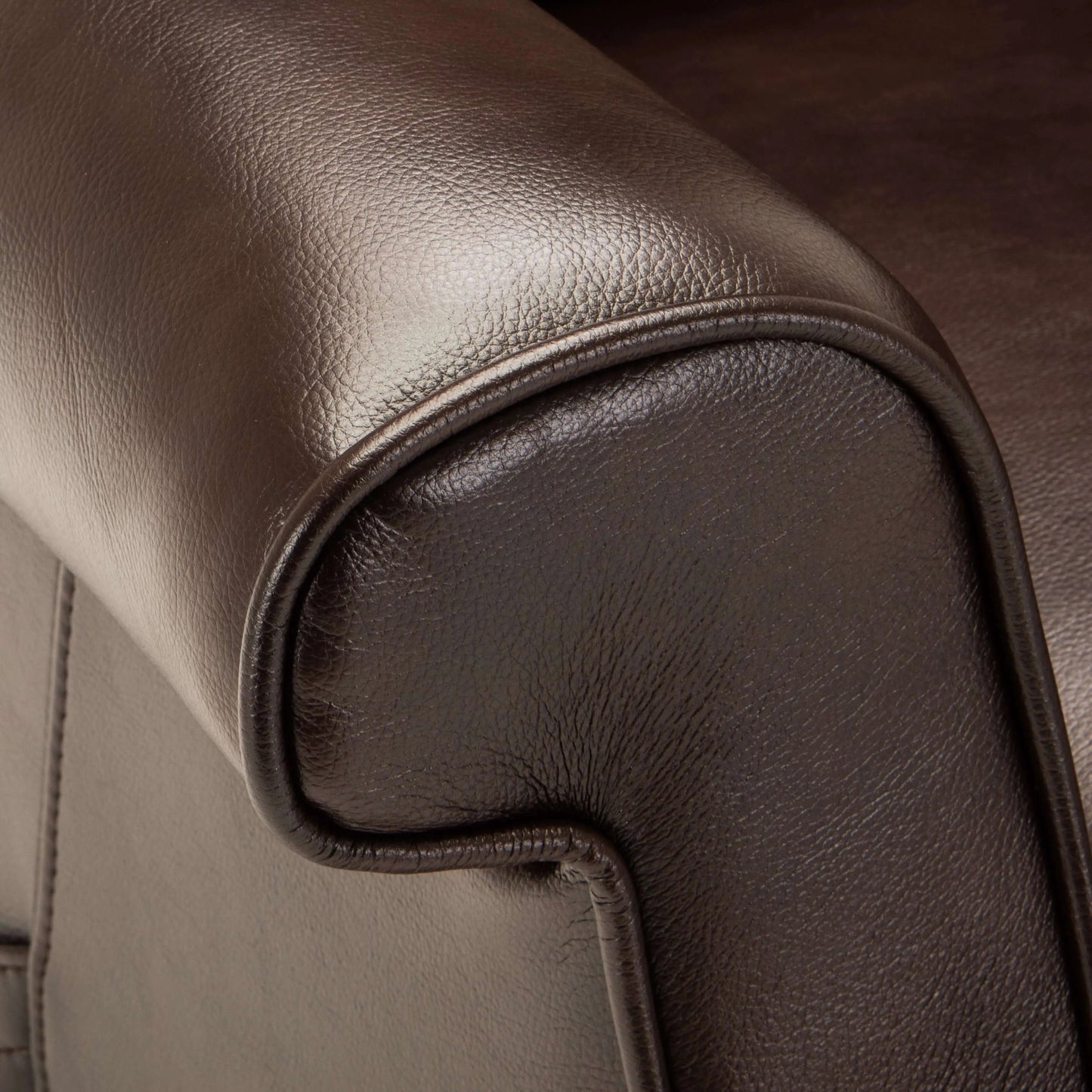 Close-up of brown leather recliner chair armrest with stitching detail
