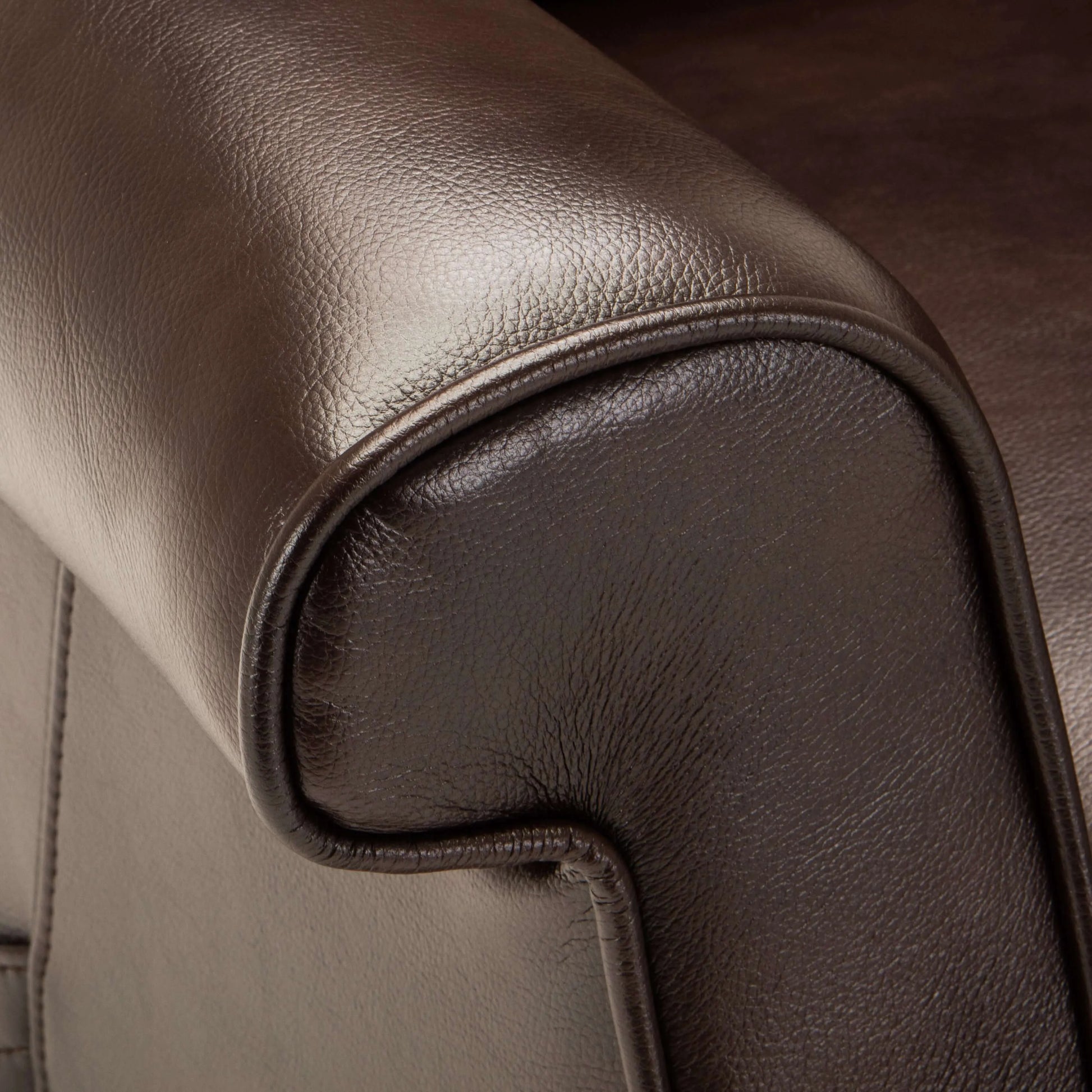 Close-up of brown leather recliner chair armrest with stitching detail