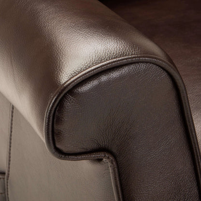 Close-up of brown leather recliner chair armrest with stitching detail