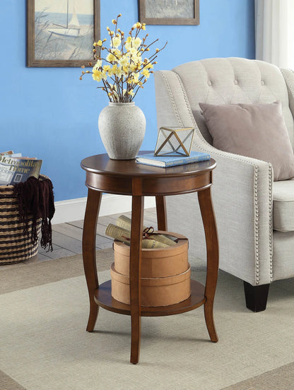 Round wooden end table with decorative items in a living room setting.