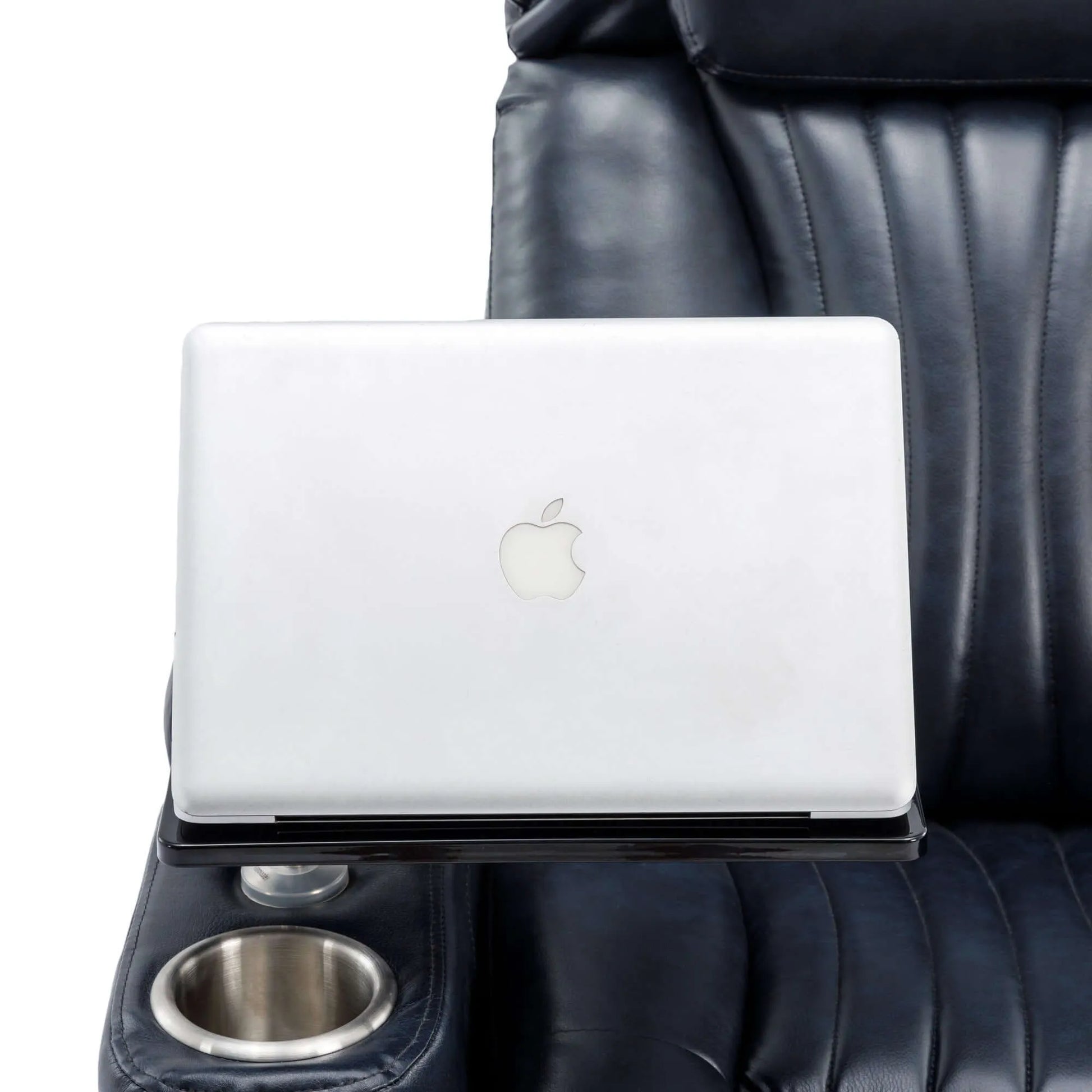 White laptop on a black table with a blue leather recliner chair with a cup holder