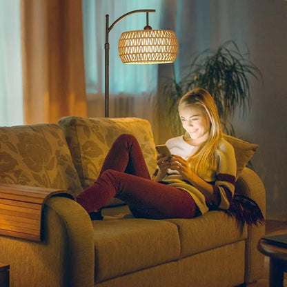 Woman sitting on a couch using a phone in a cozy living room with warm lighting.