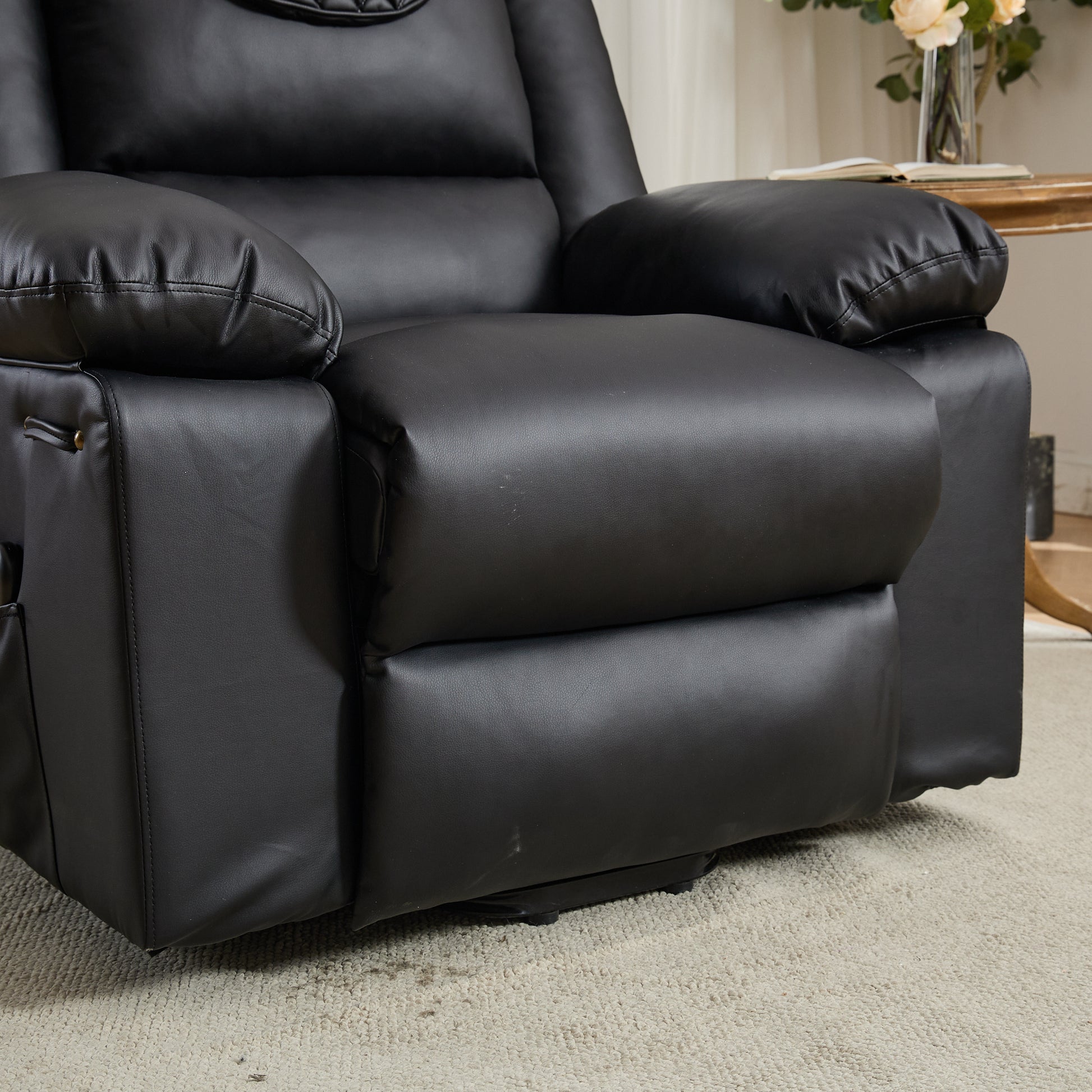 Close up of a black leather recliner chair footrest and seat cushion in a living room setting