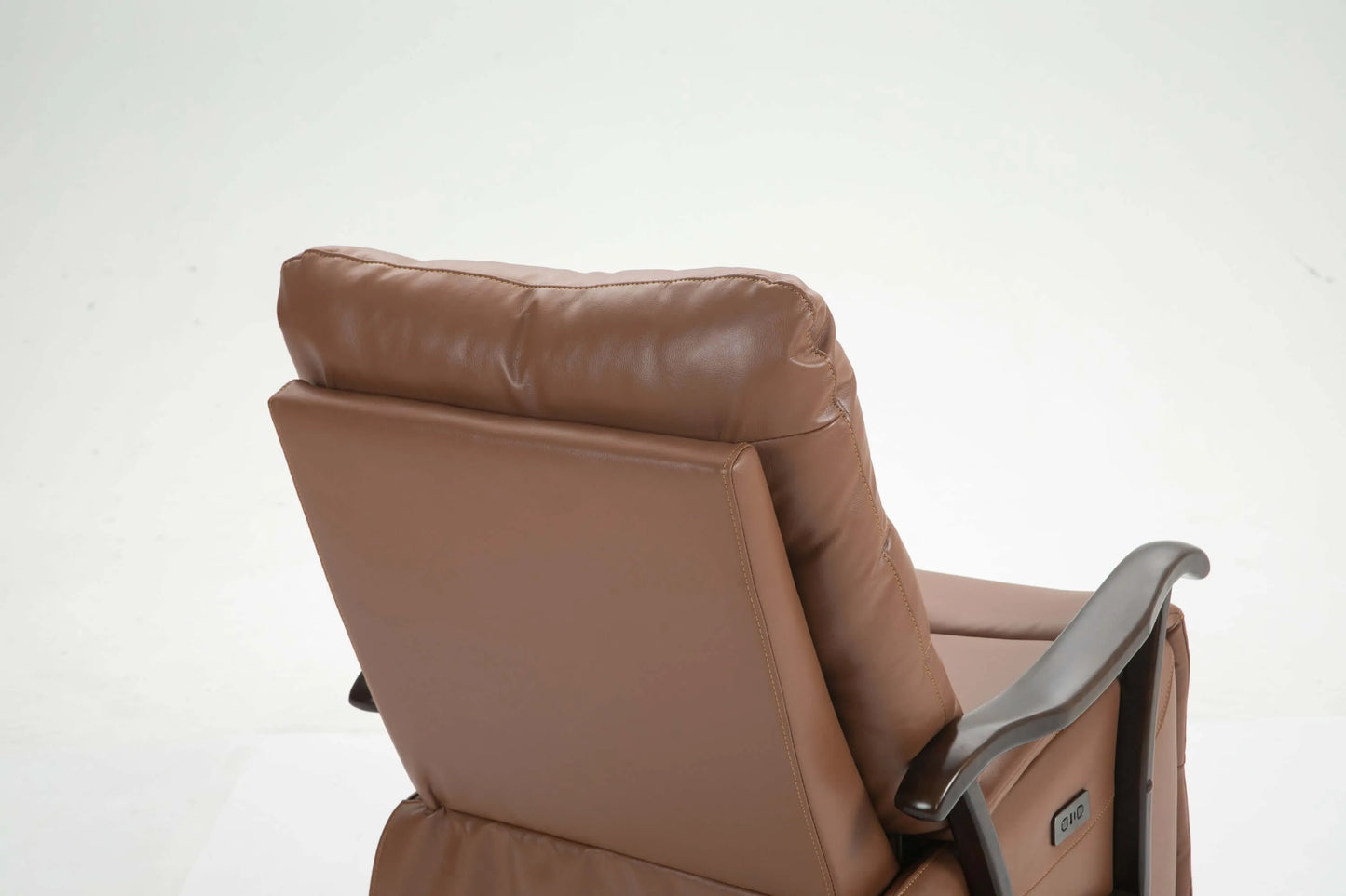 Close up of a brown leather recliner chair seat back on a white background