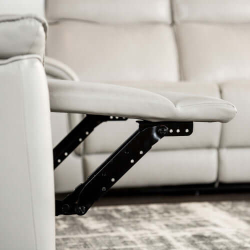 Close up of a beige leather recliner chair footrest extended in a living room setting