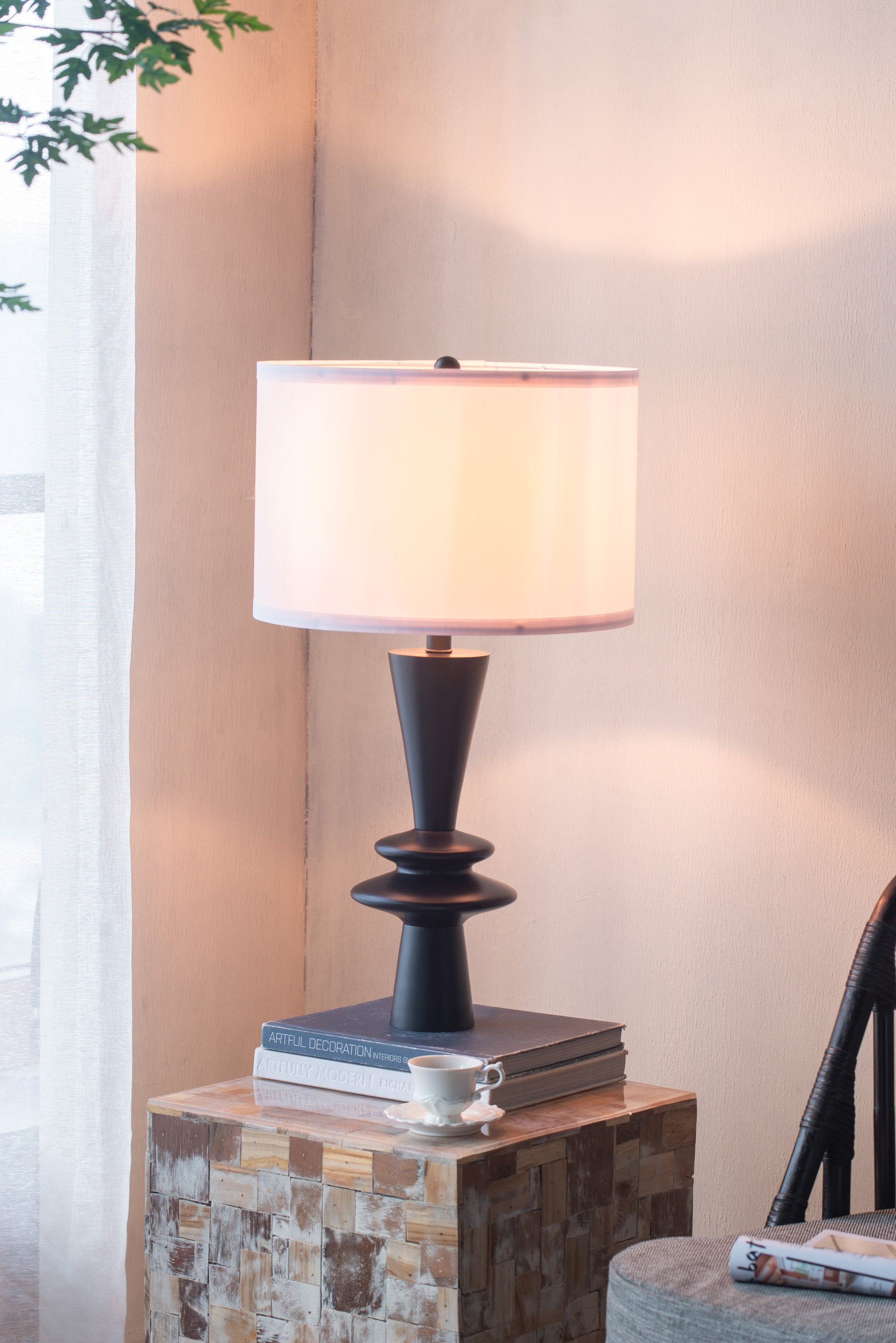 Table lamp on a wooden side table with a soft light in a room setting.