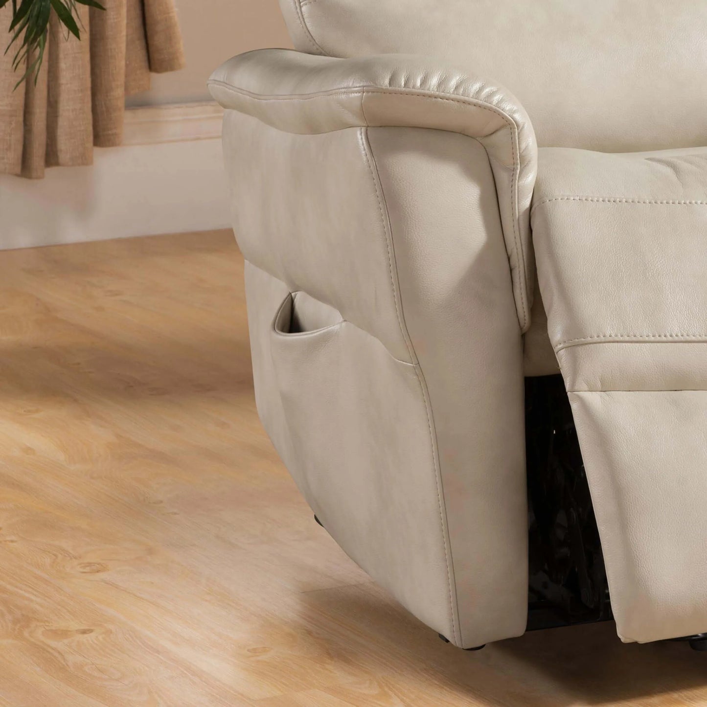 Cream color recliner chair on a wooden floor with a neutral-colored wall in the background