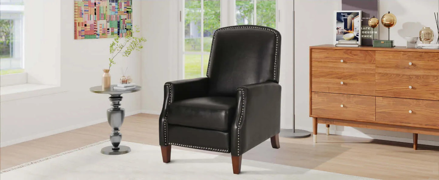 Black leather recliner chair in a living room setting with a wooden dresser and decor items.