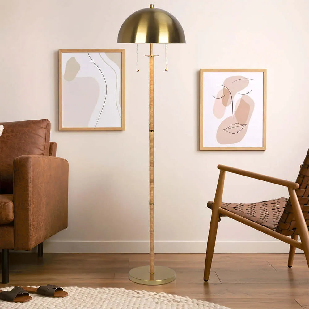 Brass floor lamp with rattan stand in a living room with abstract art on the wall