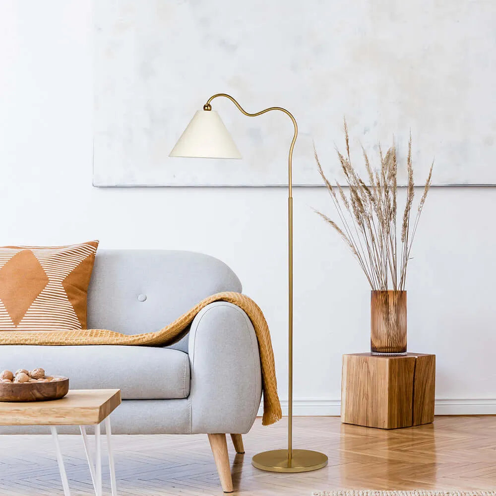 Modern living room with a gray sofa, gold floor lamp, and wooden side table.