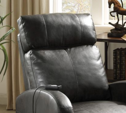 Close up of a dark brown faux leather recliner chair in a room with a desk and window.
