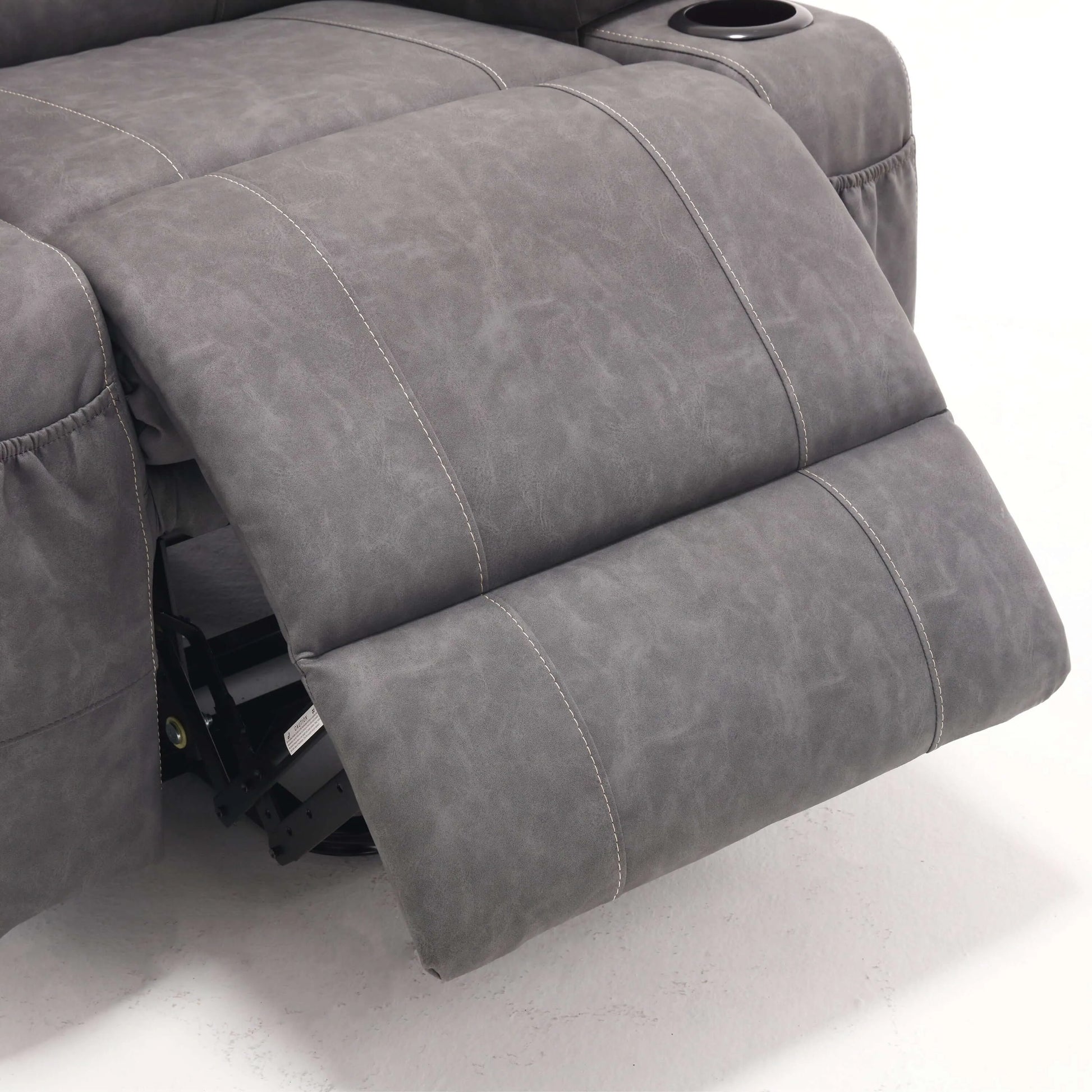 Close up of a gray faux leather power lift recliner chair footrest with detailed  stitching on a white background