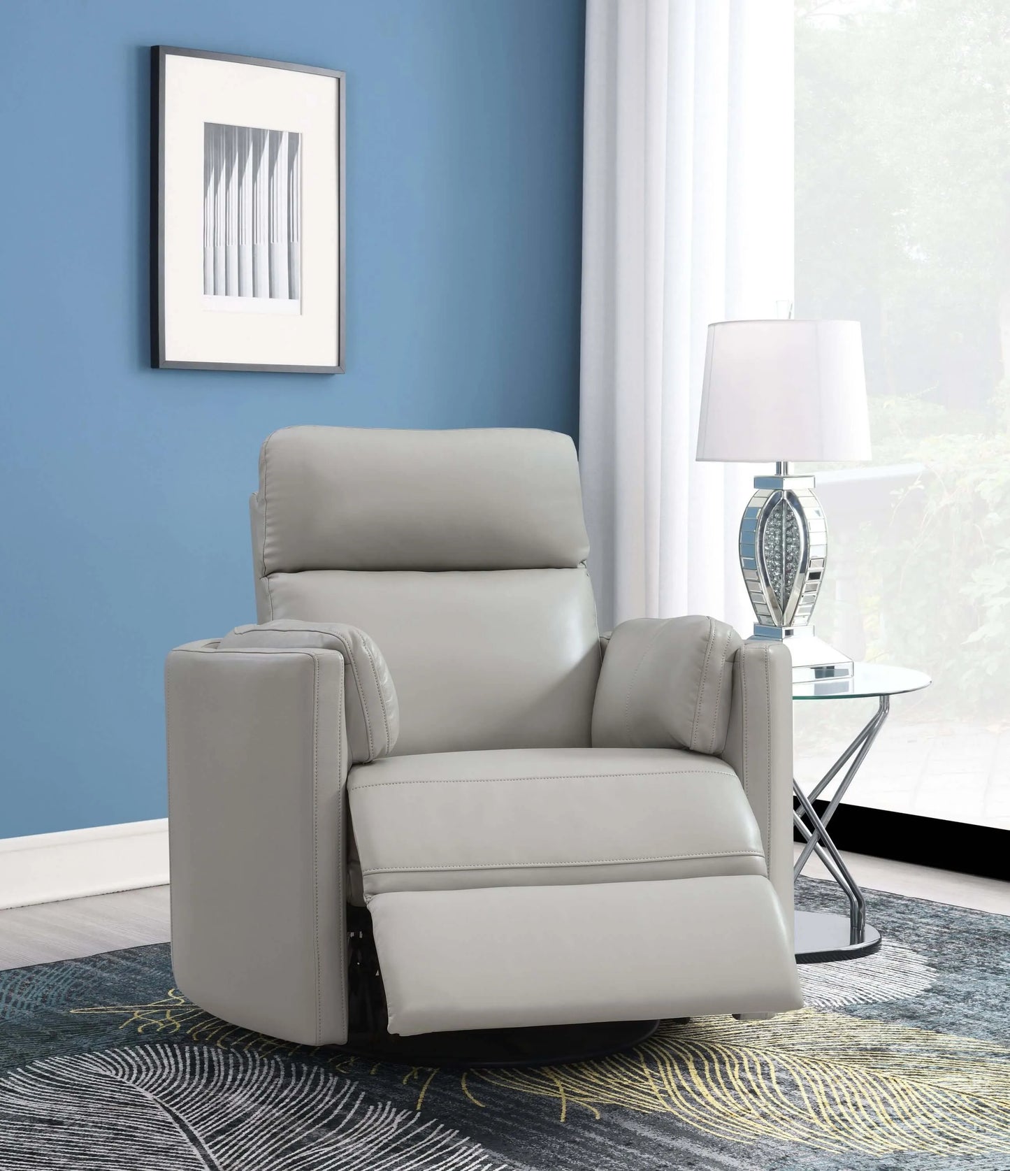 Front angle view of the Sagen Gray Faux Leather Glider Recliner with footrest extended with blue wall, glass end table and carpet.
