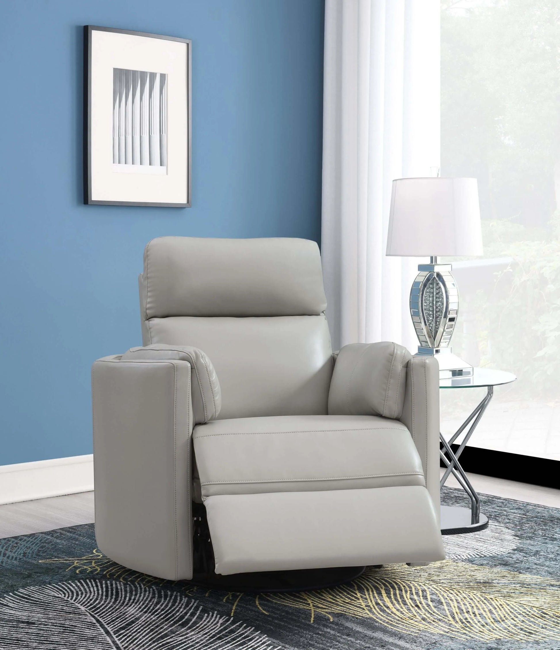 Front angle view of the Sagen Gray Faux Leather Glider Recliner with footrest extended with blue wall, glass end table and carpet.