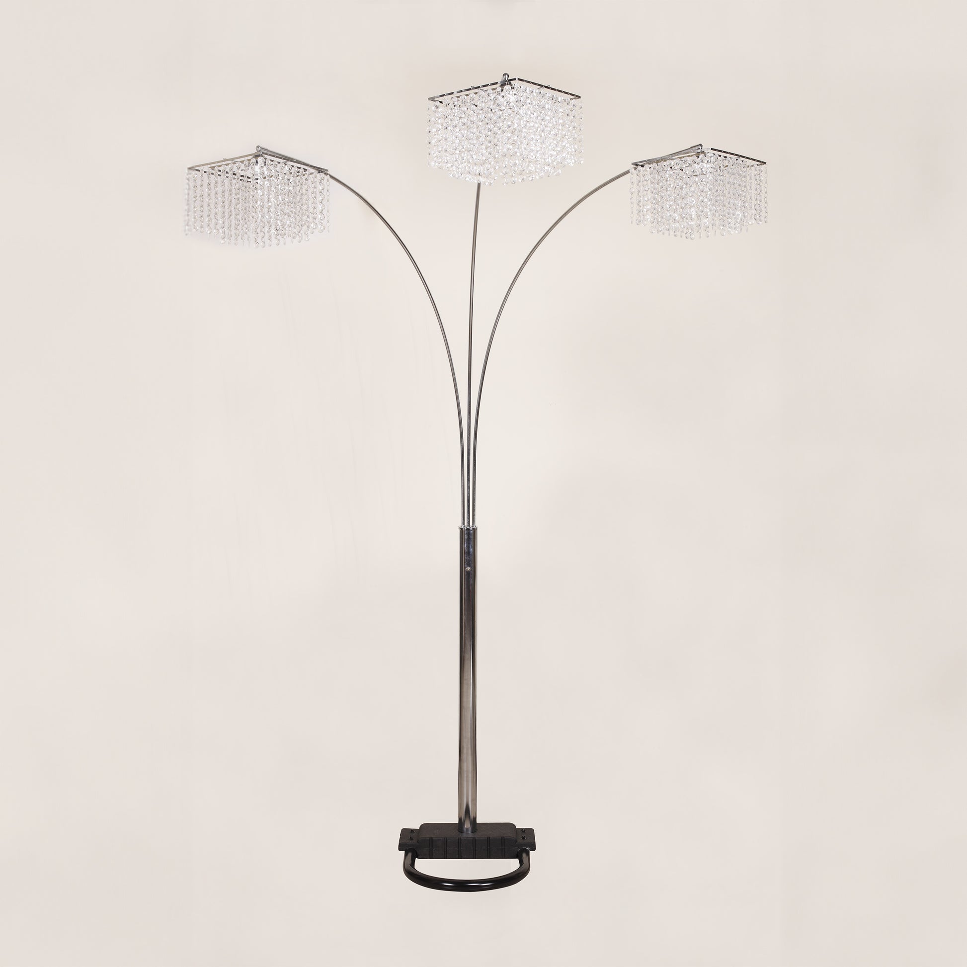 Arc floor lamp with three crystal-like shades on a beige background