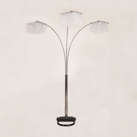 Arc floor lamp with three crystal-like shades on a beige background
