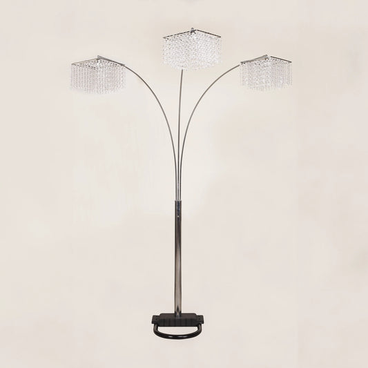 Arc floor lamp with three crystal-like shades on a beige background