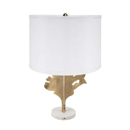 Table lamp with white shade, gold leaf design and marble base on a white background