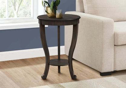 Round walnut wood side table with a plant and candle in a living room setting.