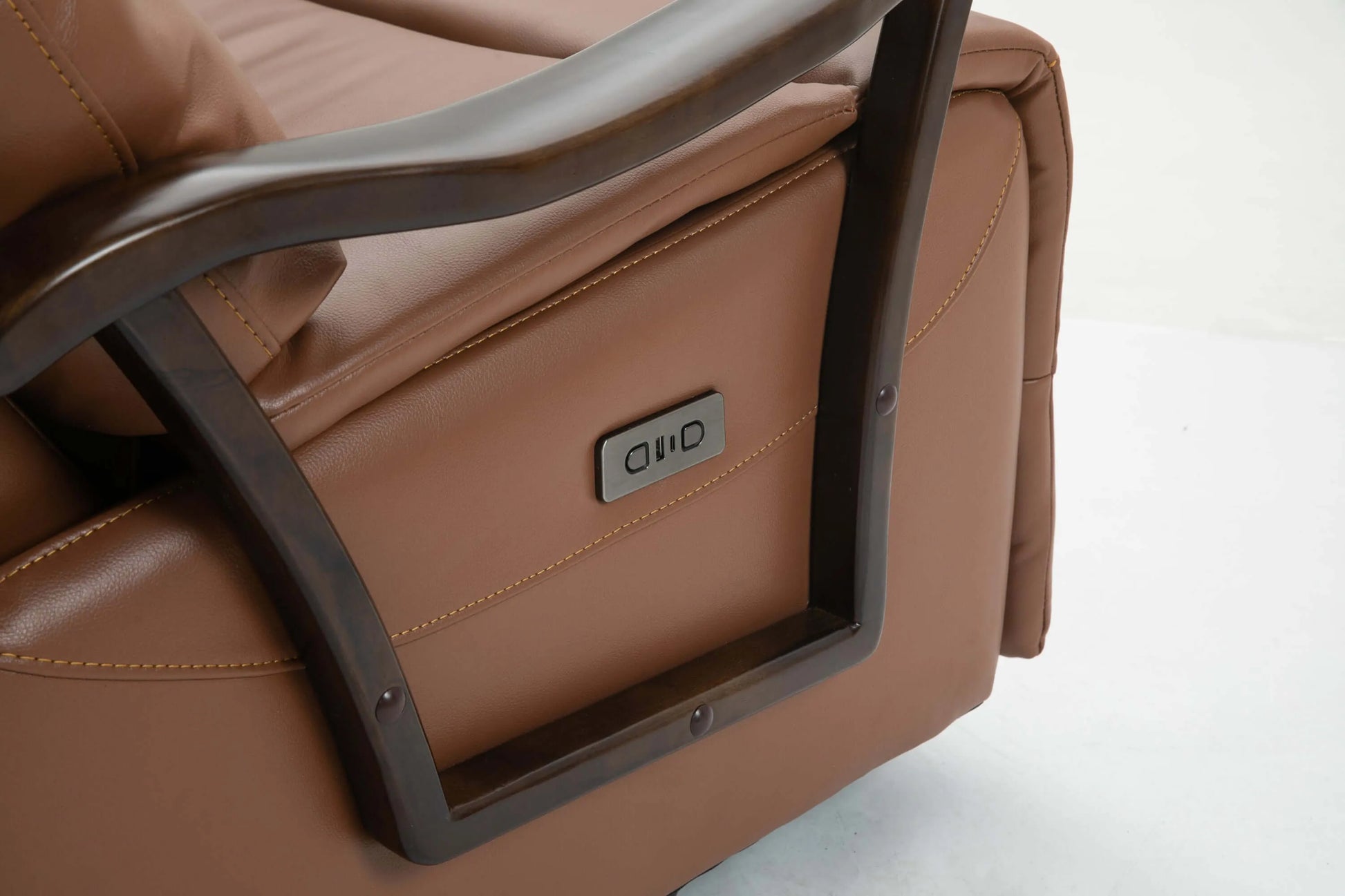 Close up of power controls on a brown leather recliner chair on a white background