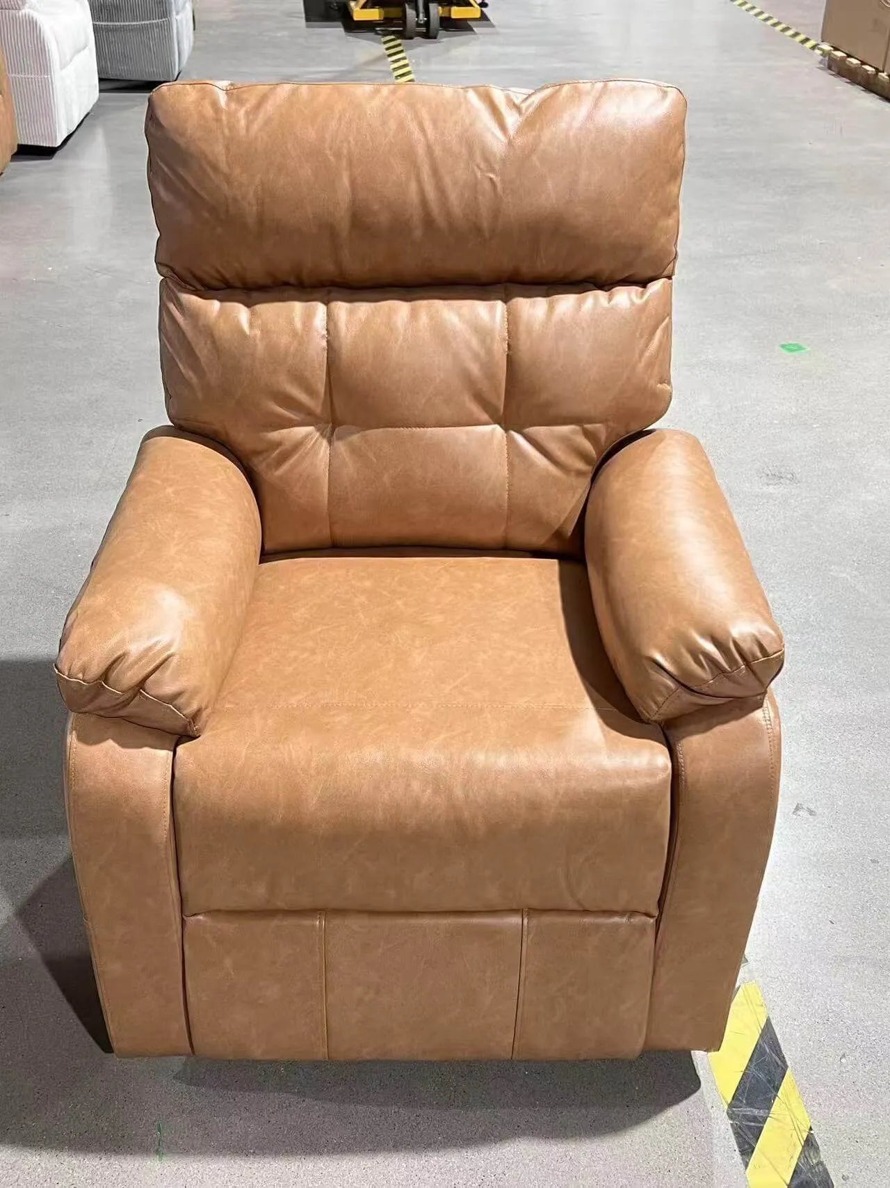 Brown leather recliner chair in a warehouse setting