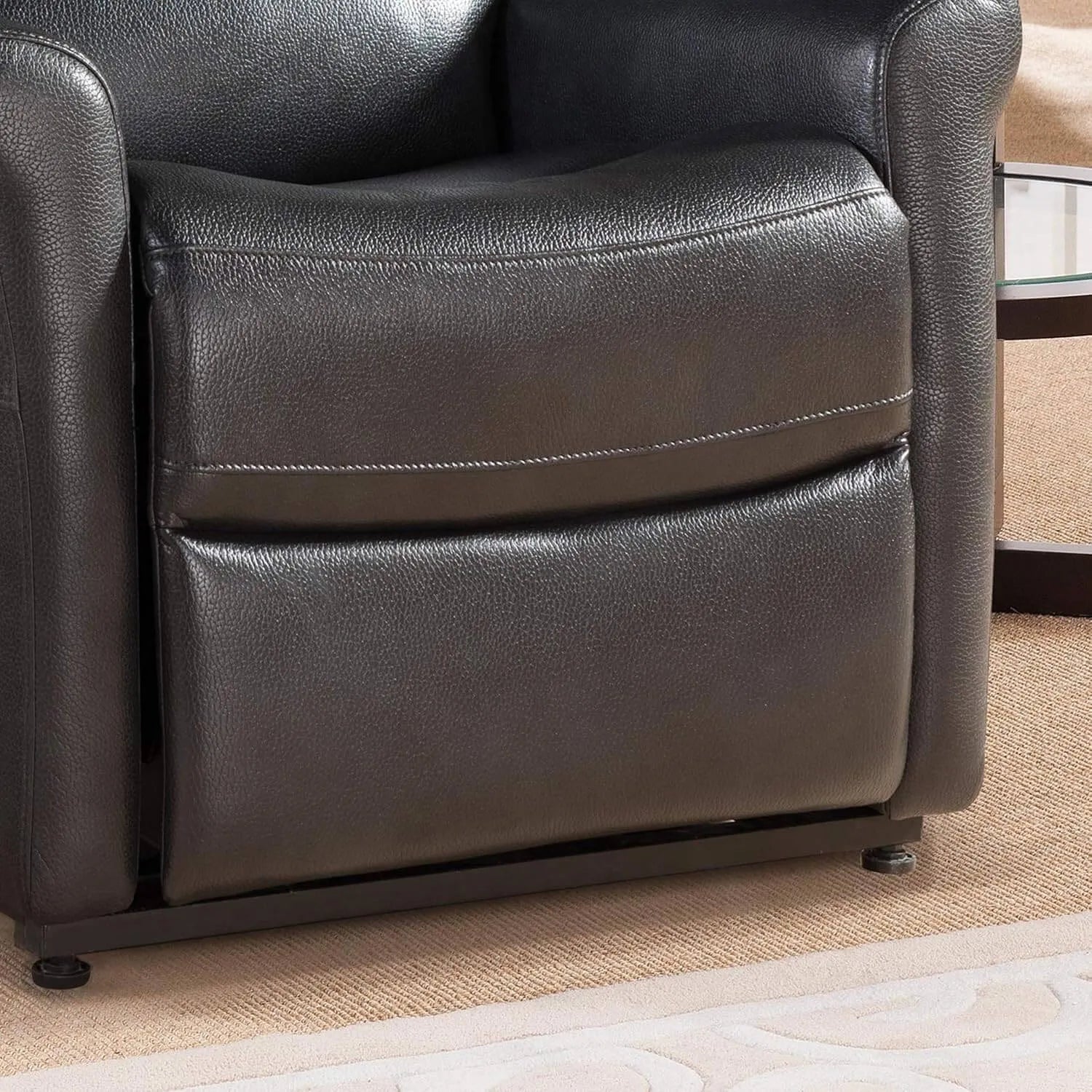 Close-up of a black faux leather recliner chair on a beige carpet