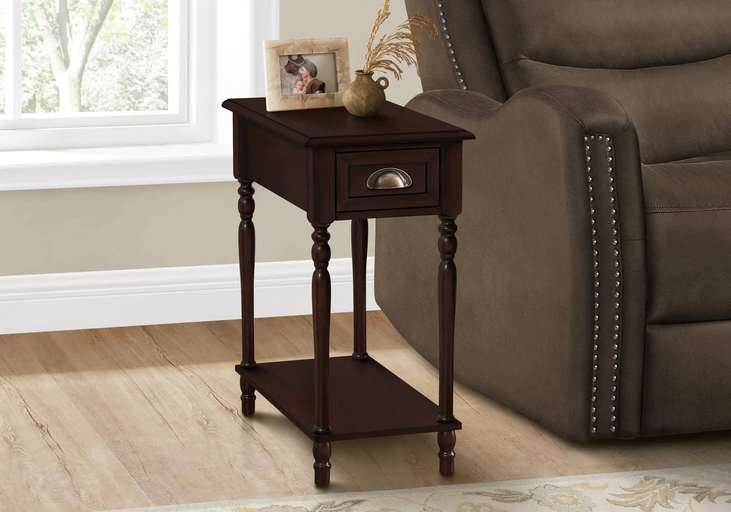 Cherry brown wooden end table with a brown finish next to a brown recliner chair in a room with a window.
