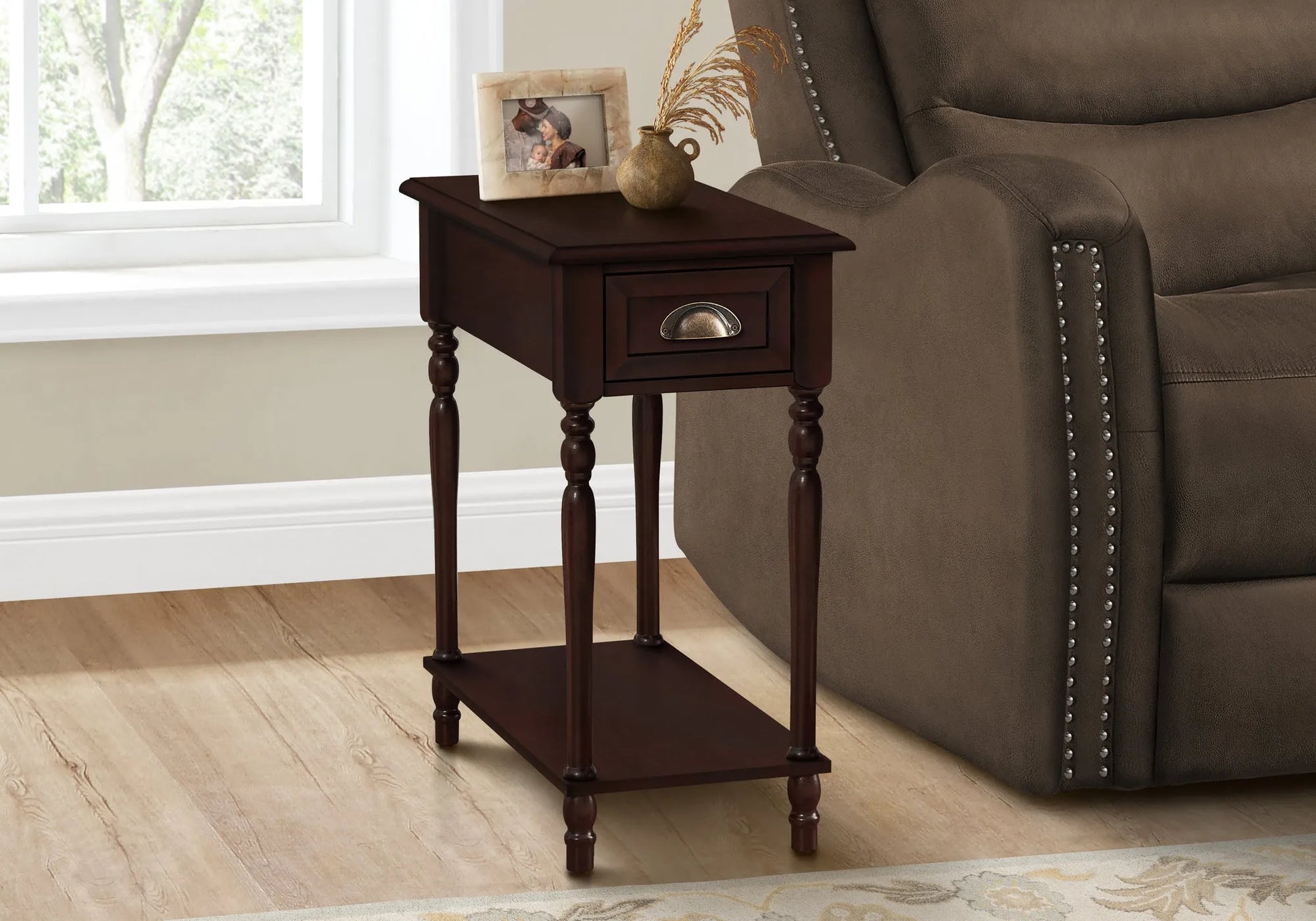Cherry brown wooden end table with a brown finish next to a brown recliner chair in a room with a window.
