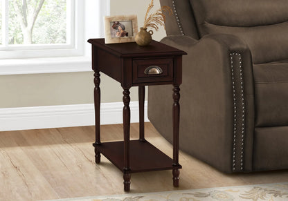 Cherry brown wooden end table with a brown finish next to a brown recliner chair in a room with a window.