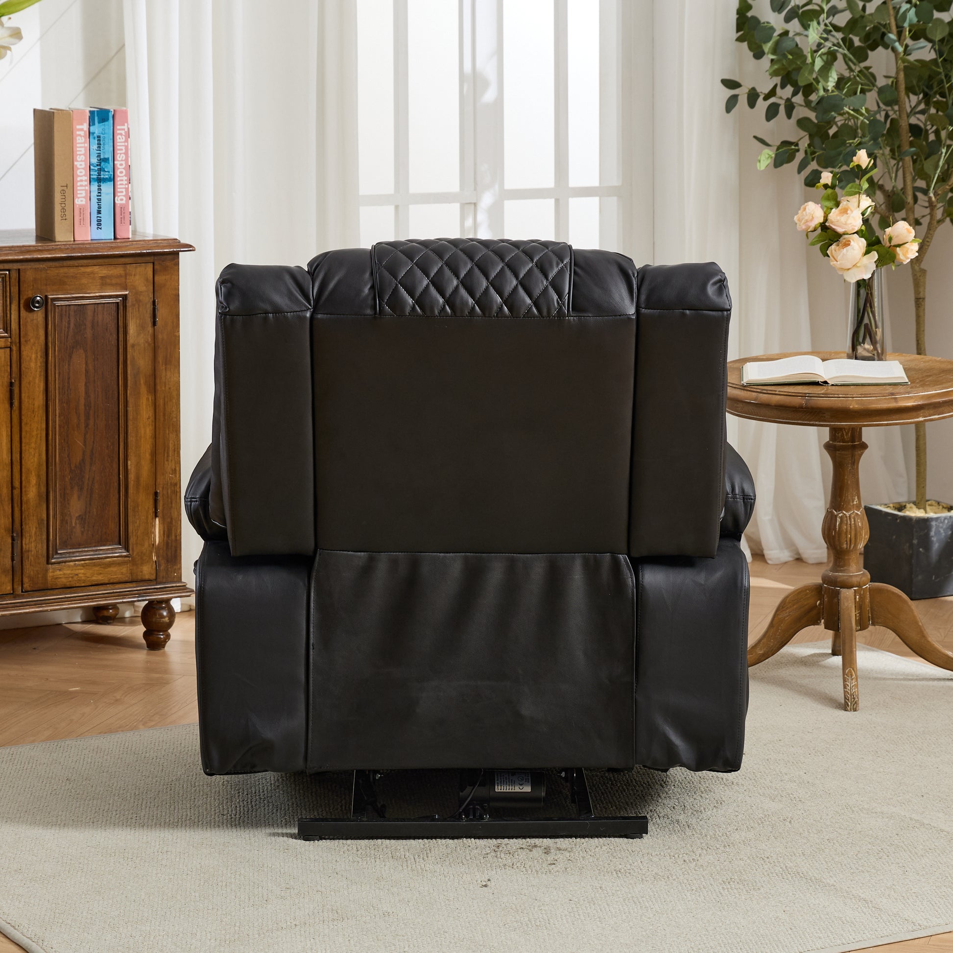 Black leather recliner chair in a living room setting with wooden furniture and decor.