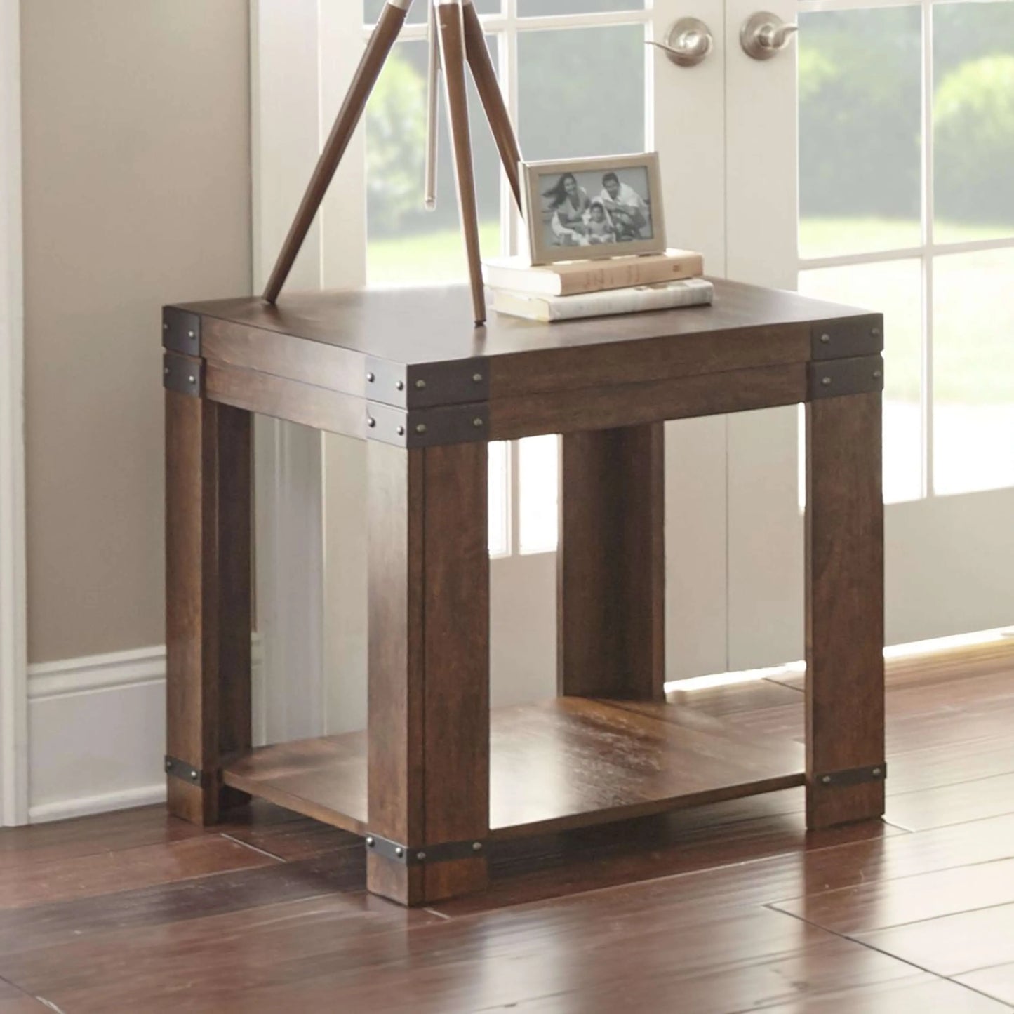 Wooden end table with a bottom shelf in a room with windows