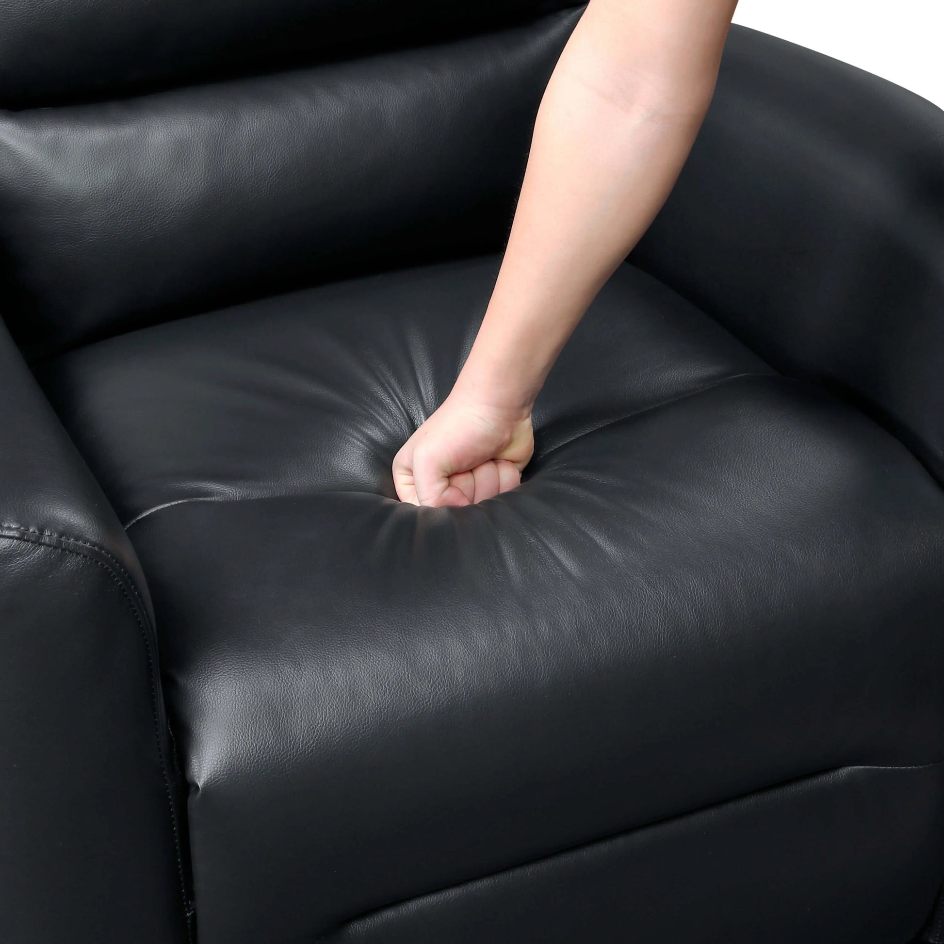 Person's hand on a black leather recliner chair seat cushion
