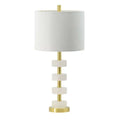 Table lamp with white shade and marble-like accents and gold base on a white background