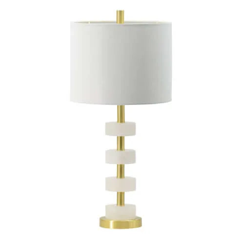 Table lamp with white shade and marble-like accents and gold base on a white background