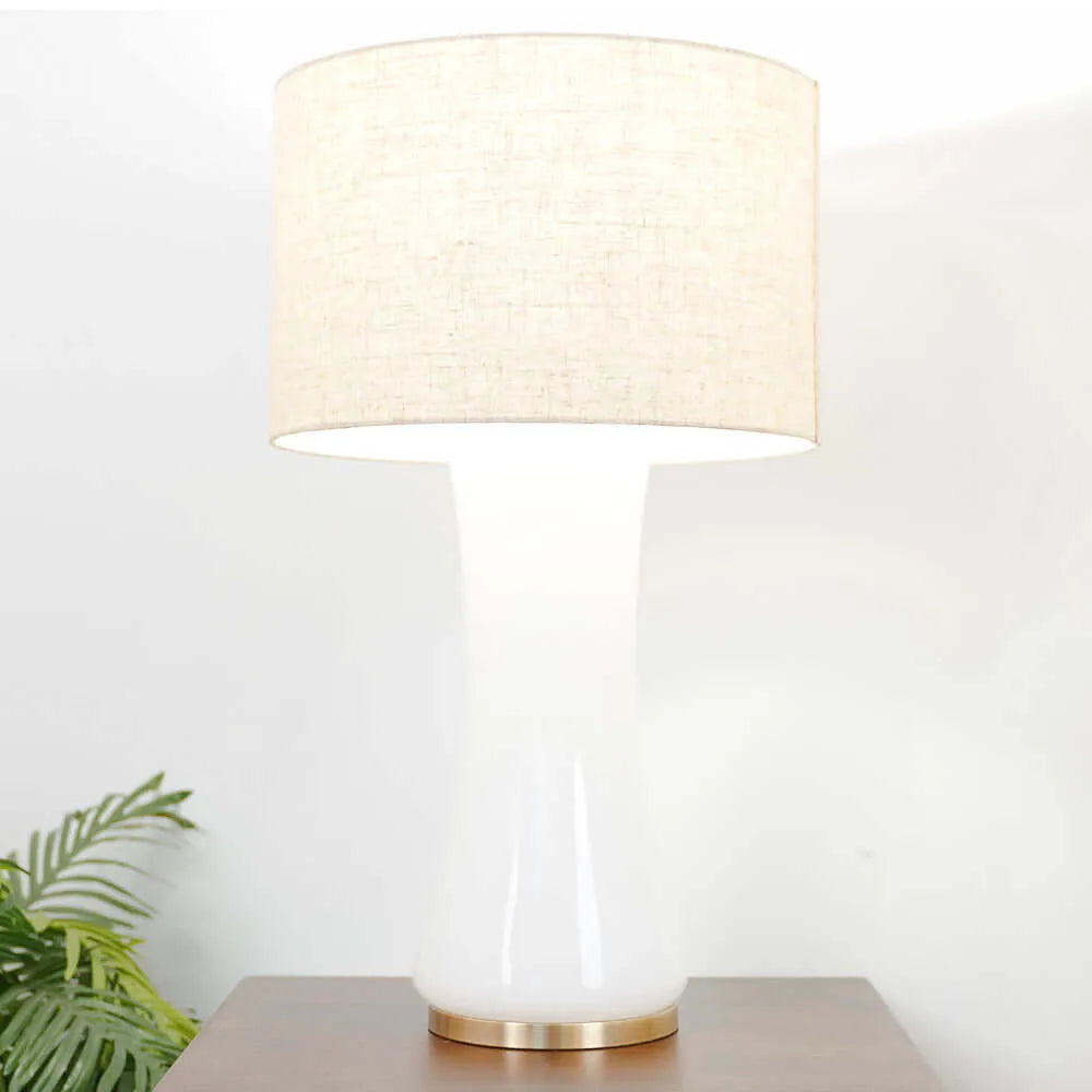 Illuminated table lamp with a beige shade on a white background