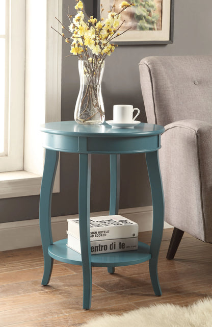 Teal end table with a vase of yellow flowers and books in a room setting.