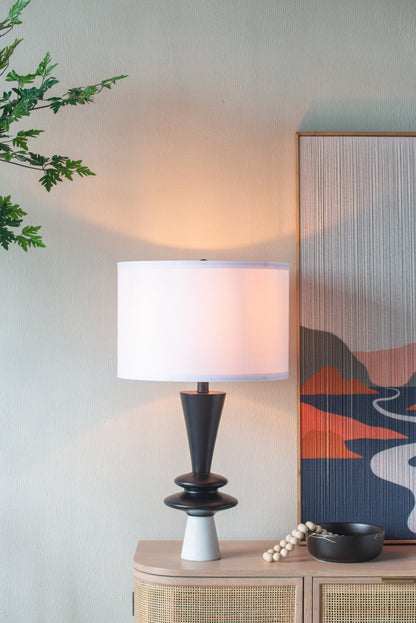 Table lamp on a side table with a decorative painting in the background