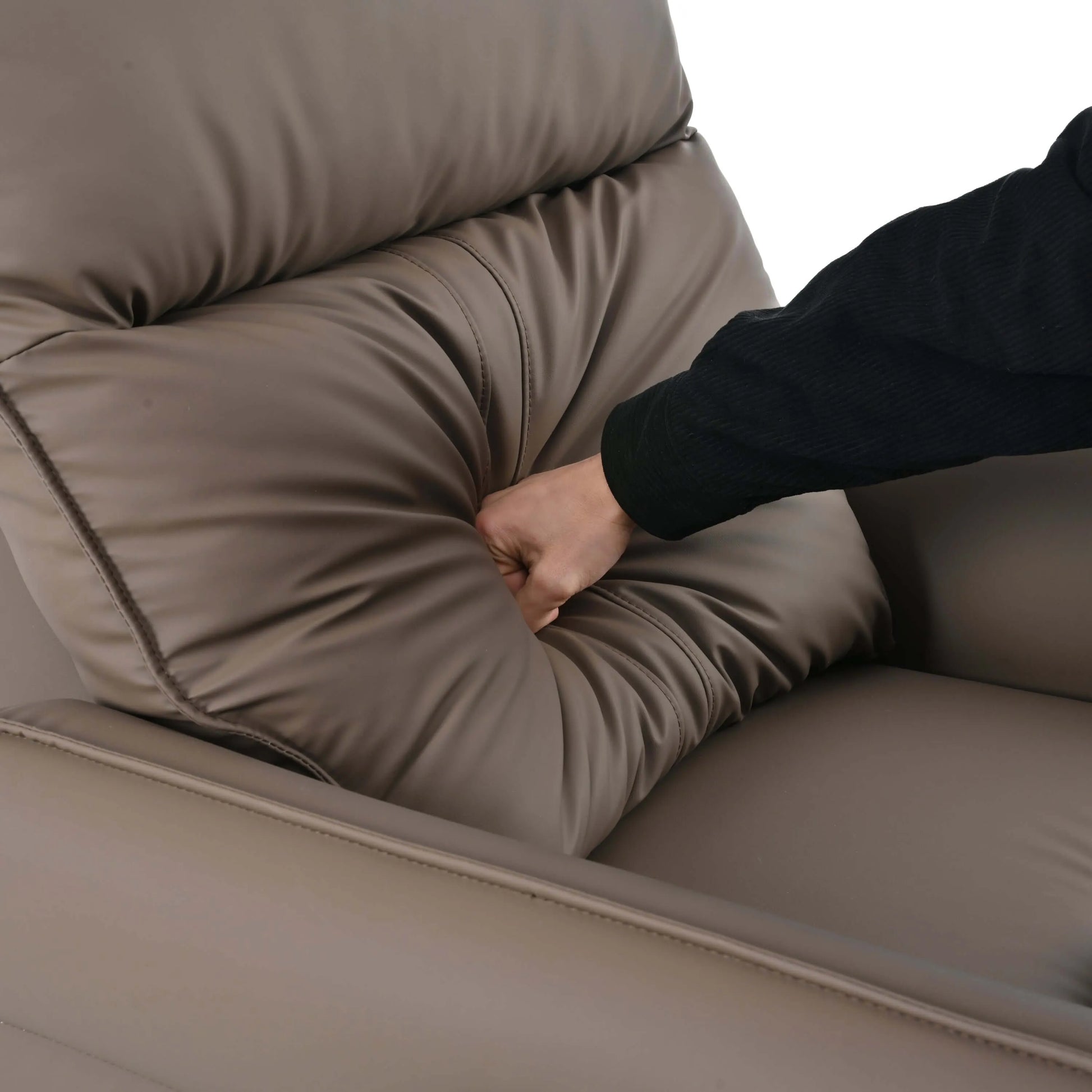 Person punching back cushion of a brown leather swivel recliner chair on a white background