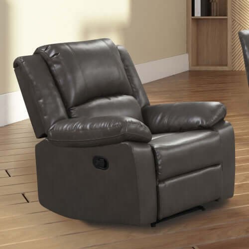 Angled gray faux leather recliner chair in a room with wooden flooring and a bookshelf.