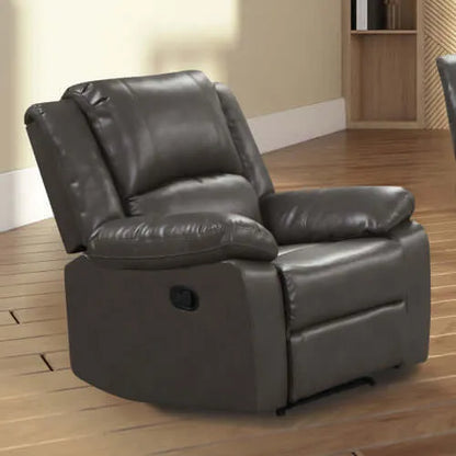 Angled gray faux leather recliner chair in a room with wooden flooring and a bookshelf.