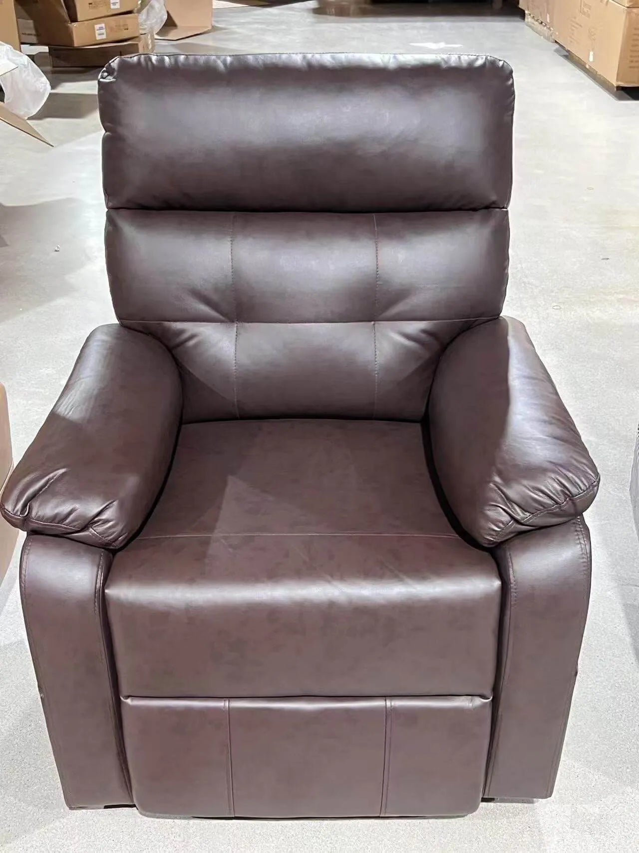 Brown leather recliner chair in a warehouse setting