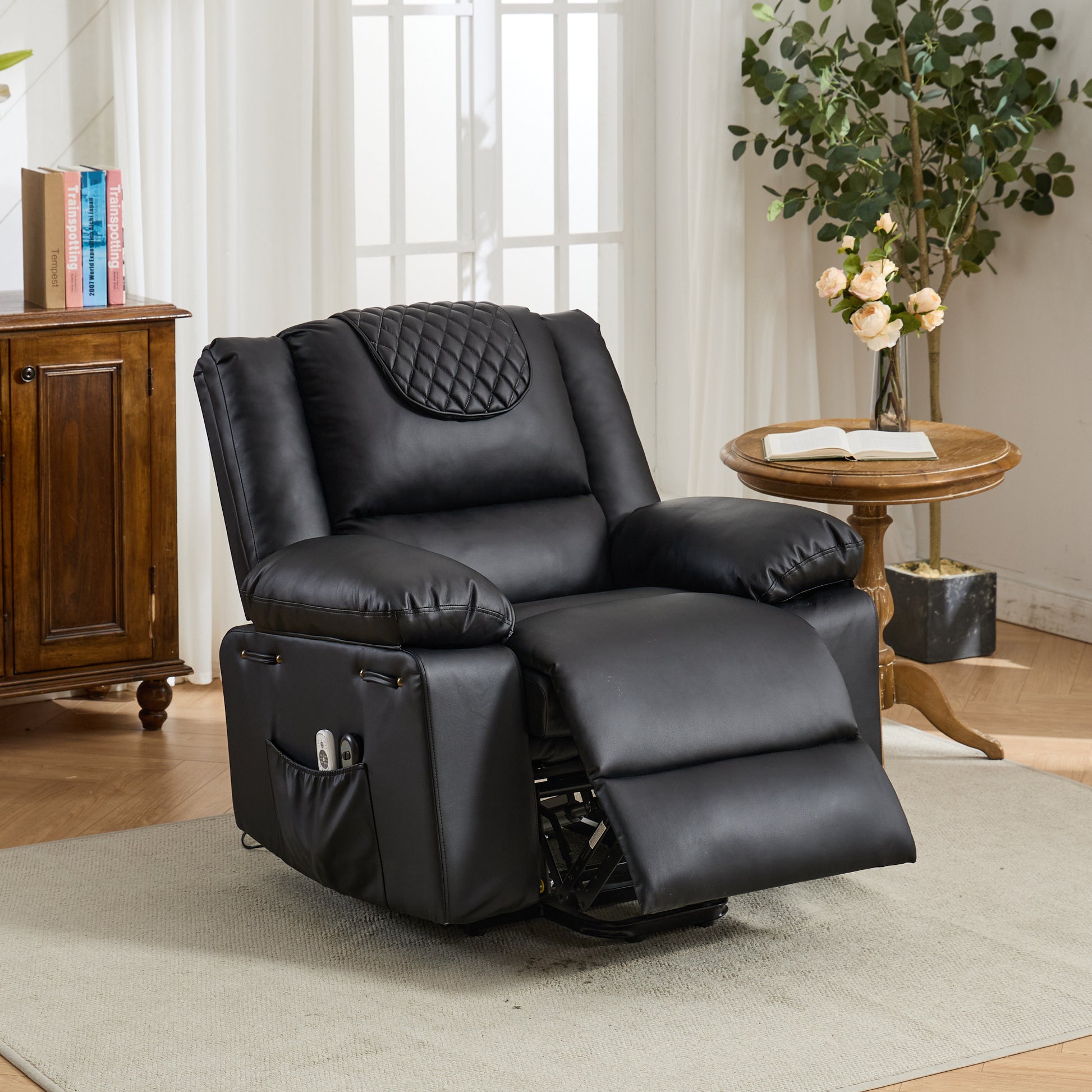 Black leather recliner chair in a living room setting with a wooden cabinet and table in the background.