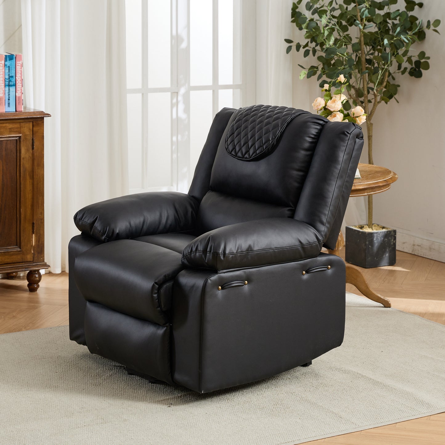 Black leather recliner chair in a living room setting with a plant and wooden cabinet.